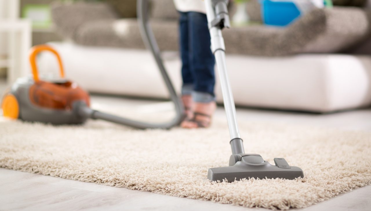 Close up of vacuuming carpet with vacuum cleaner