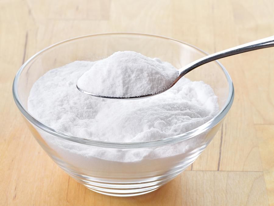 Baking soda in a glass bowl with one spoon