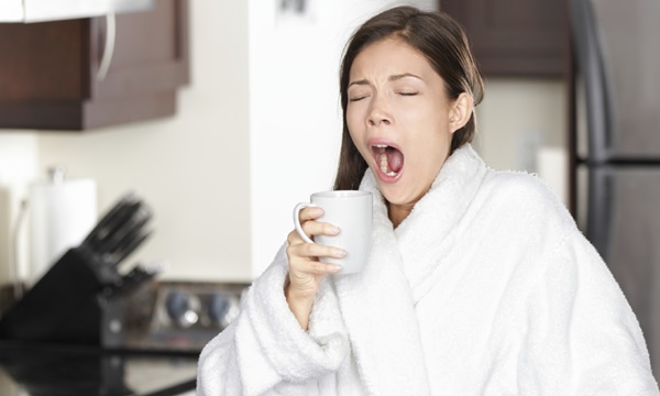 Yawning coffee woman in morning