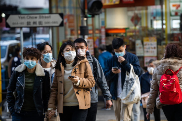 HONG KONG, CHINA - 2020/01/30: Residents seen wearing surgical masks while crossing the road in order to prevent the spread of the Wuhan corona virus. The World Health Organization called a meeting of its Emergency Committee Thursday to consider issuing a global alarm as the death toll from the spreading coronavirus rose to 170 and the number of cases jumped to over 7000. (Photo by Geovien So/SOPA Images/LightRocket via Getty Images)